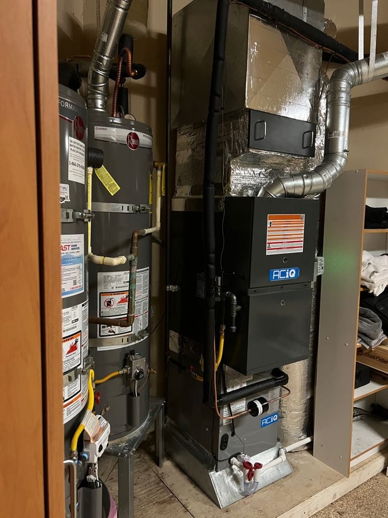 Home HVAC system with water heater on left and furnace unit on right with metal ductwork